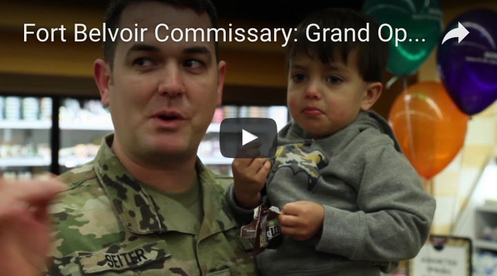 Thumbnail image of the Fort Belvoir grand opening video.  A man in uniform holds his son. 