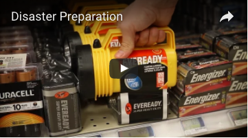 Screenshot of the Disaster Preparation YouTube video. A person grabs a bright yellow emergency flashlight from a shelf next to batteries.