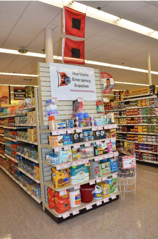 A Commissary end cap is shown with hurricane emergency supplies displayed.