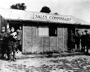 Black and white photo of soldiers standing outside of a makeshift Commissary in France, circa 1918.