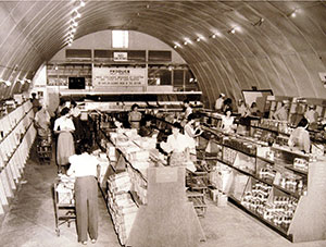 Sepia toned picture of shoppers inside of a commissary at the Navy Supply Depot, Guam, circa 1951.