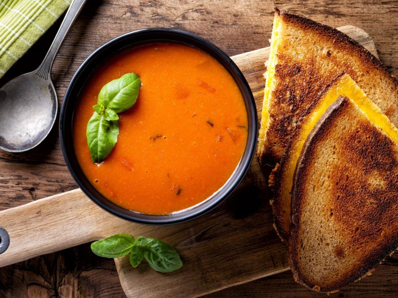 Bowl of tomato and and two grilled cheese halves