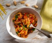 Bowl of spaghetti in marinera sauce with white beans and parsley.